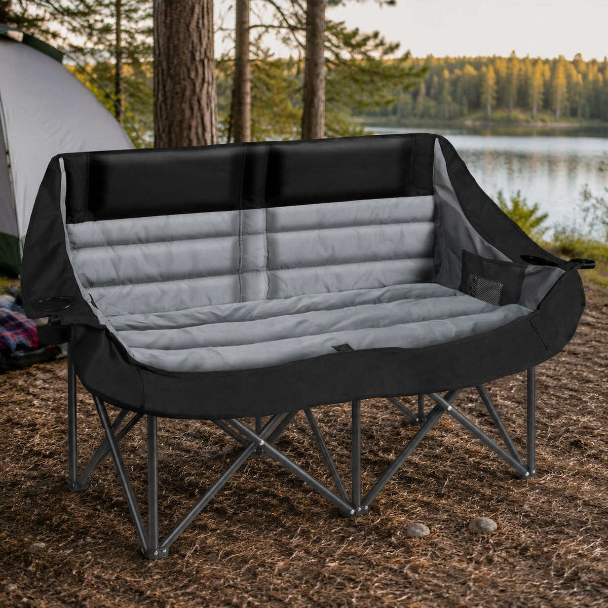 Black and gray double camping chair fully opened at a lakeside campsite