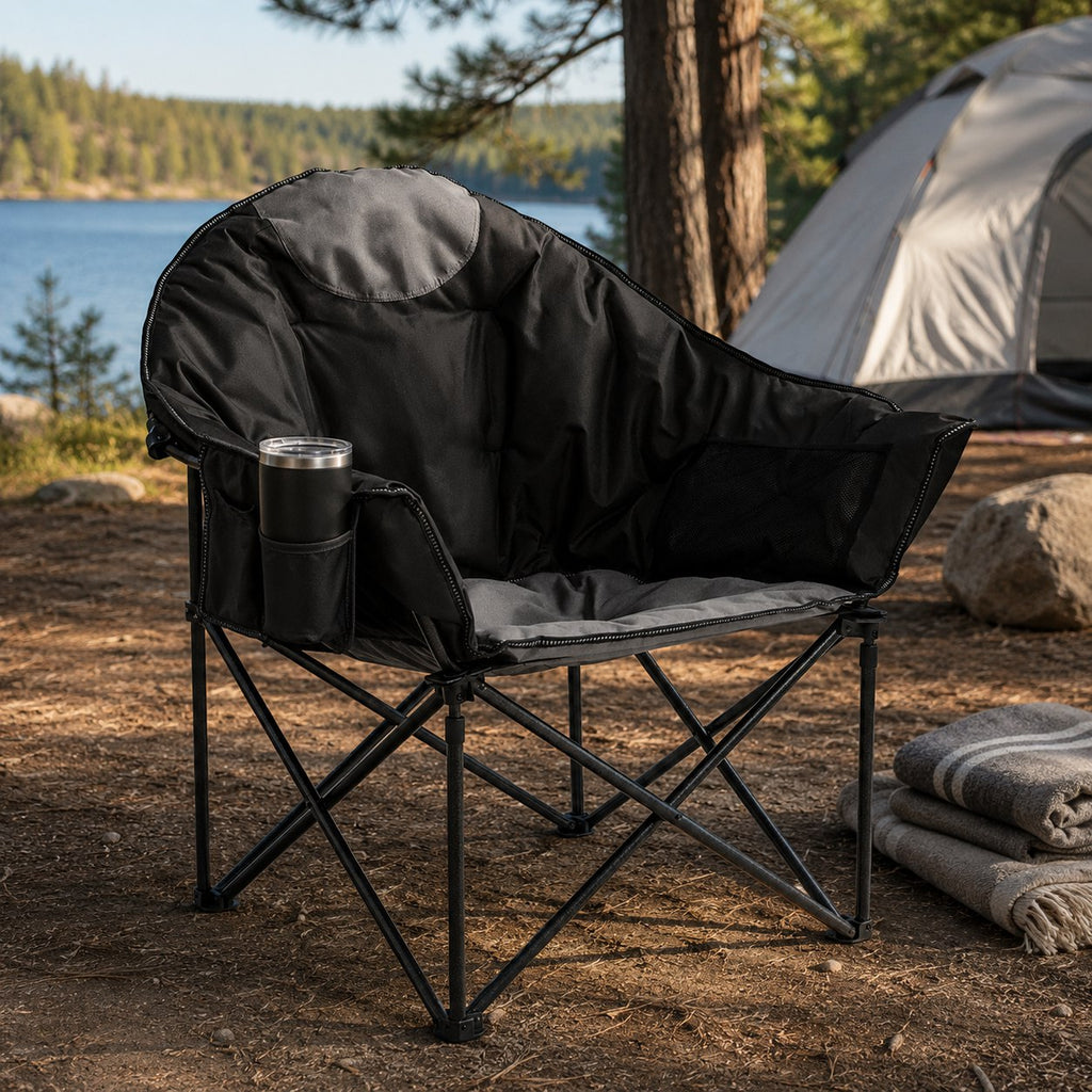 Black moon saucer folding chair opened beside a tent at a lakeside campsite
